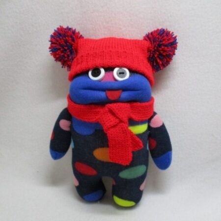 Great little character, very colourful. Wearing a machine knitted hat with two pompoms and a matching scarft. Weird and wonderful !